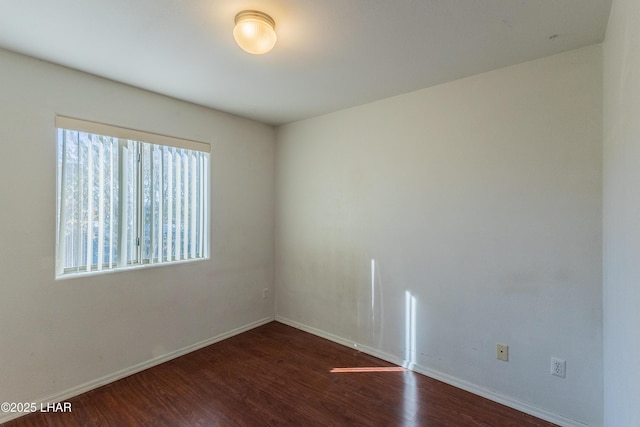 spare room with wood finished floors and baseboards