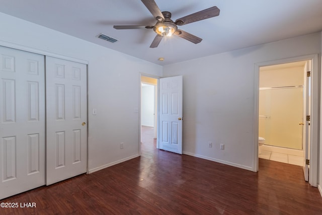 unfurnished bedroom with baseboards, visible vents, dark wood-style flooring, ceiling fan, and a closet