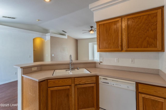 kitchen with a sink, dishwasher, a peninsula, and light countertops