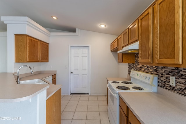 kitchen featuring white range with electric cooktop, under cabinet range hood, a sink, a peninsula, and brown cabinetry