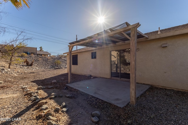 rear view of property with a patio and stucco siding