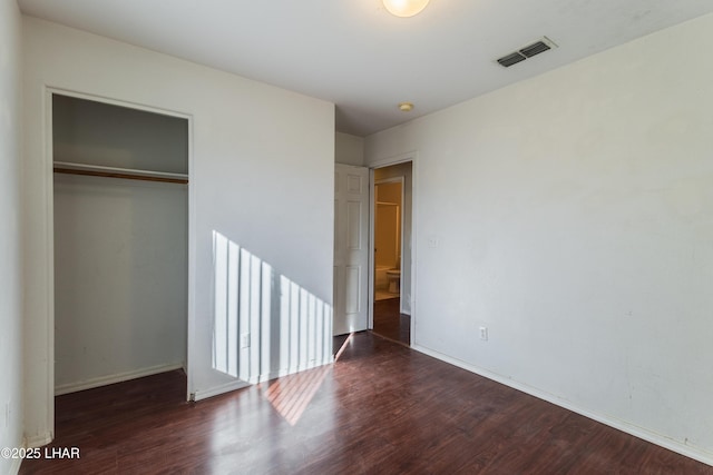 unfurnished bedroom with visible vents, baseboards, a closet, and wood finished floors