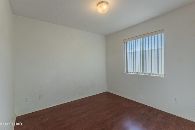 unfurnished room with baseboards and wood finished floors