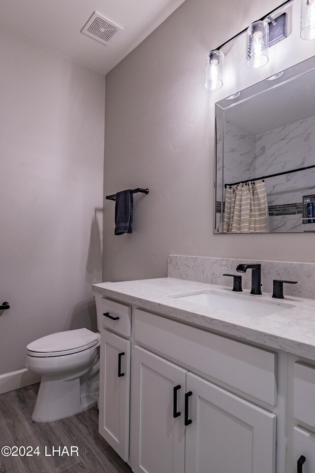 bathroom with vanity, curtained shower, toilet, and hardwood / wood-style flooring