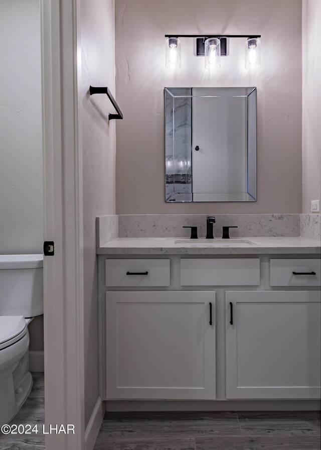 bathroom with vanity, hardwood / wood-style floors, and toilet