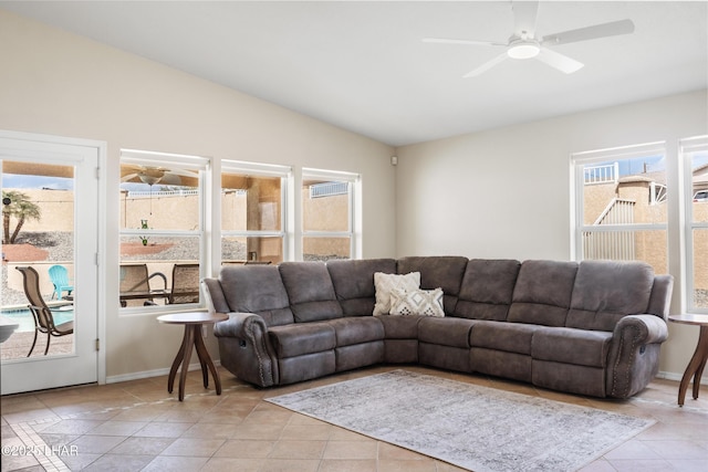 living room featuring vaulted ceiling, light tile patterned flooring, baseboards, and ceiling fan