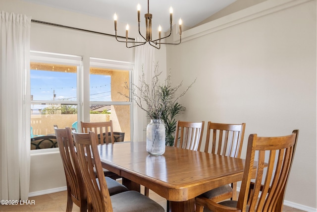 dining area with baseboards, a notable chandelier, and lofted ceiling