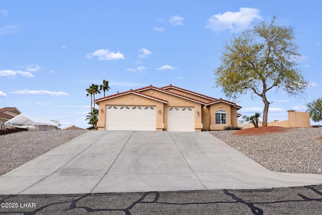 view of front of property with stucco siding, concrete driveway, an attached garage, and a tiled roof