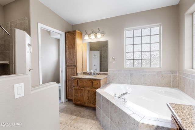 bathroom featuring tiled shower, a bath, vanity, and tile patterned flooring