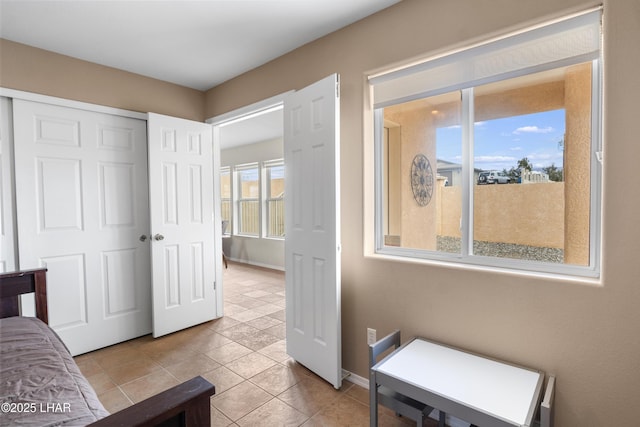 bedroom featuring a closet, tile patterned floors, and baseboards