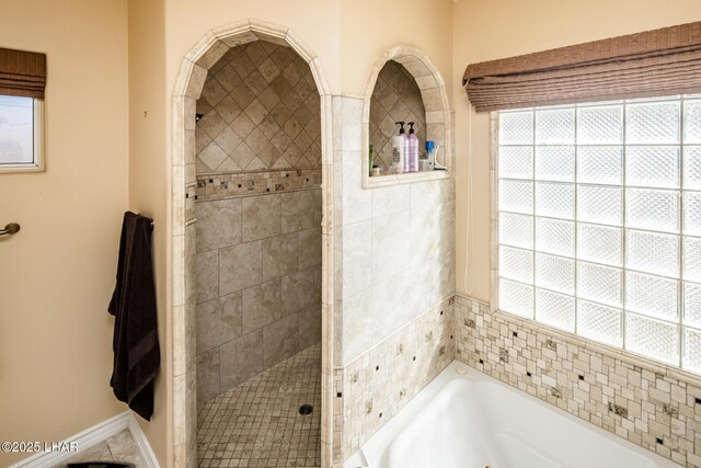 bathroom featuring independent shower and bath and a healthy amount of sunlight