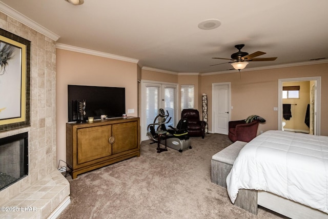 carpeted bedroom featuring connected bathroom, crown molding, a fireplace, and ceiling fan