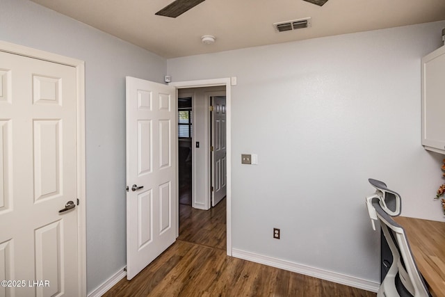 unfurnished office featuring ceiling fan and dark wood-type flooring