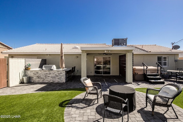 rear view of house featuring central air condition unit, an outdoor kitchen, an outdoor bar, and a patio area