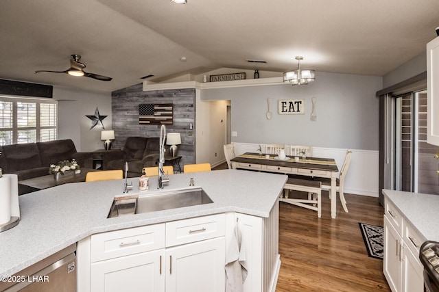 kitchen with lofted ceiling, white cabinetry, hardwood / wood-style flooring, and decorative light fixtures