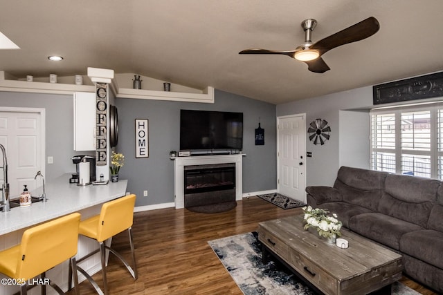 living room with dark wood-type flooring, vaulted ceiling, and ceiling fan