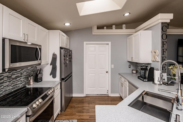 kitchen with white cabinets, stainless steel appliances, and dark hardwood / wood-style flooring