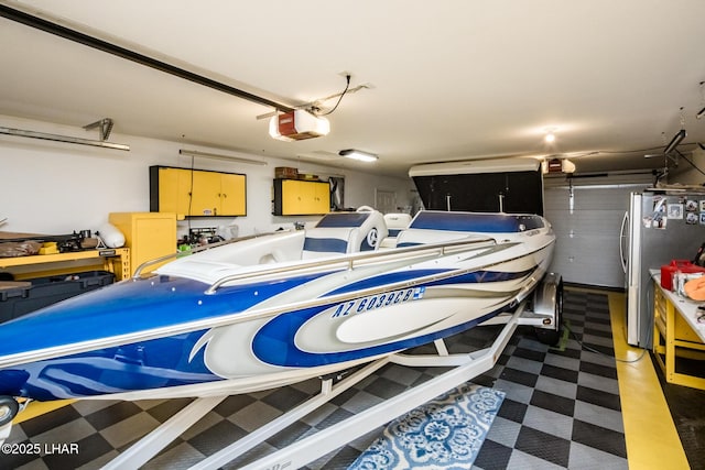 garage with a garage door opener and stainless steel fridge