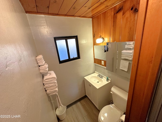 9378 Riverside Dr, Parker, AZ 85344 - bathroom featuring toilet, wood ceiling, wood finished floors, and vanity