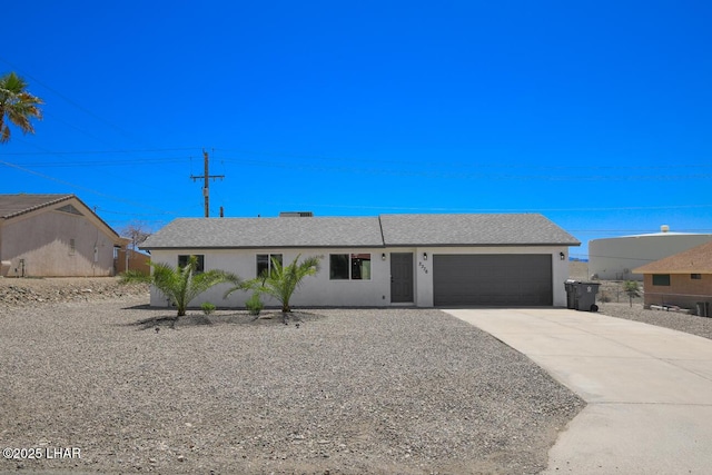single story home featuring driveway, a garage, and stucco siding