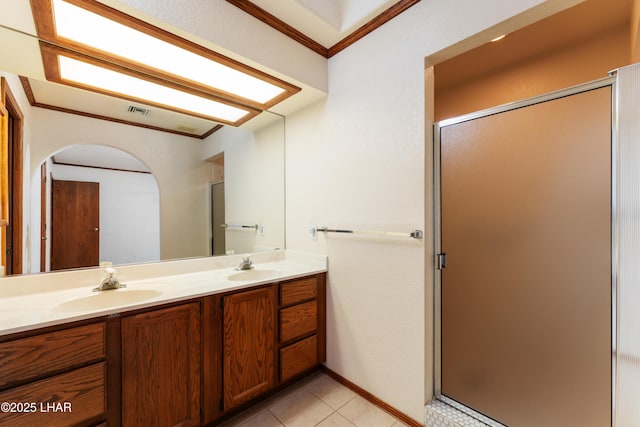 full bathroom featuring tile patterned floors, ornamental molding, a sink, a shower stall, and double vanity