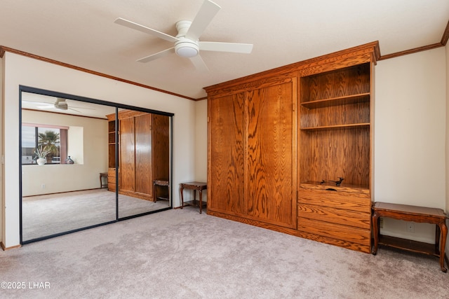 unfurnished bedroom with a closet, carpet floors, ceiling fan, and crown molding