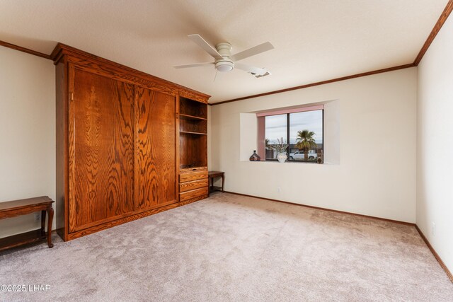 unfurnished bedroom with a ceiling fan, baseboards, light colored carpet, and crown molding