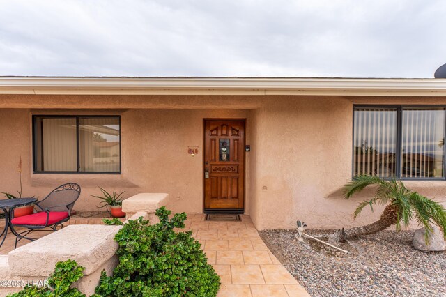 view of exterior entry featuring stucco siding