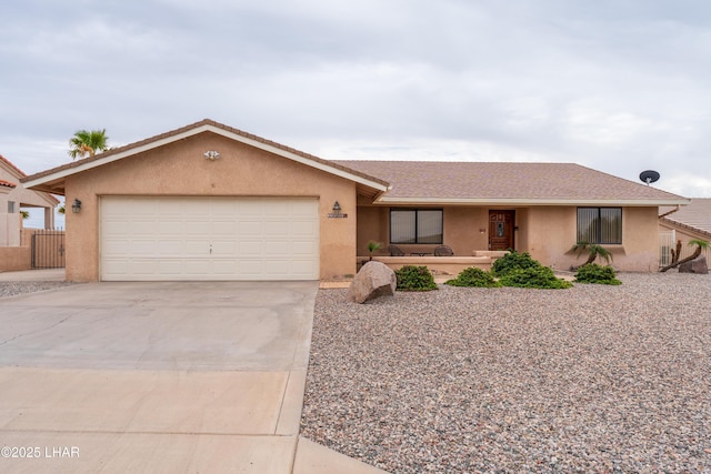 single story home with stucco siding, a garage, and driveway