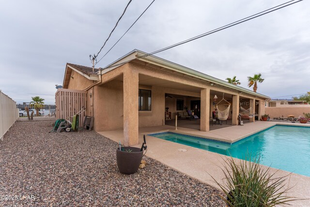 back of house with a patio area, stucco siding, a fenced backyard, and a fenced in pool