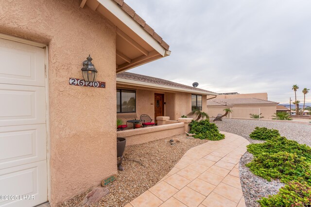 doorway to property with stucco siding and a garage