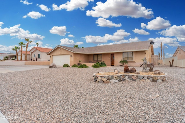 view of front of house with stucco siding, an attached garage, concrete driveway, and fence