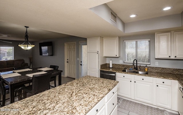 kitchen featuring white cabinetry, sink, dark stone countertops, and dishwasher