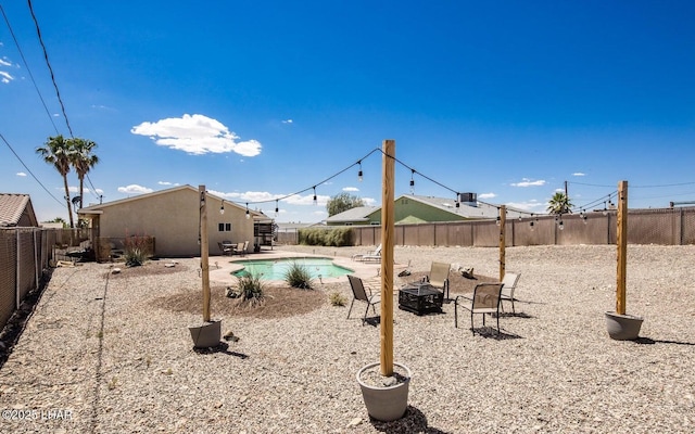 view of yard with a fenced in pool, a patio, and a fire pit