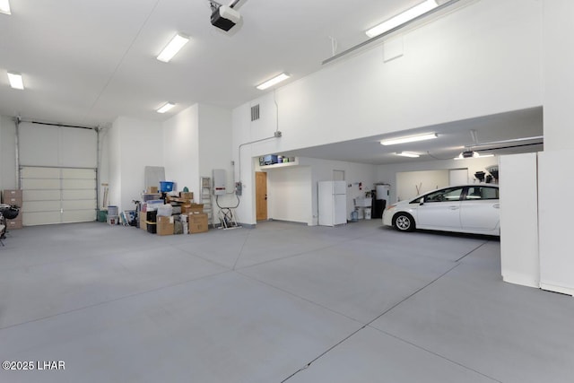 garage with a garage door opener and electric water heater