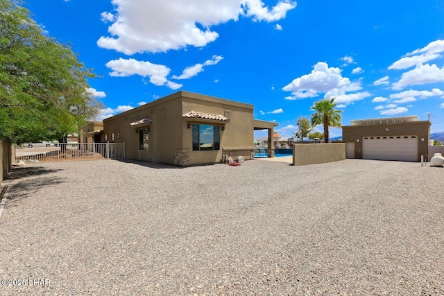 view of property exterior featuring a garage, fence, and stucco siding