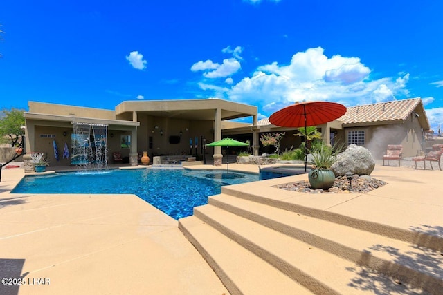 pool with a patio and an in ground hot tub