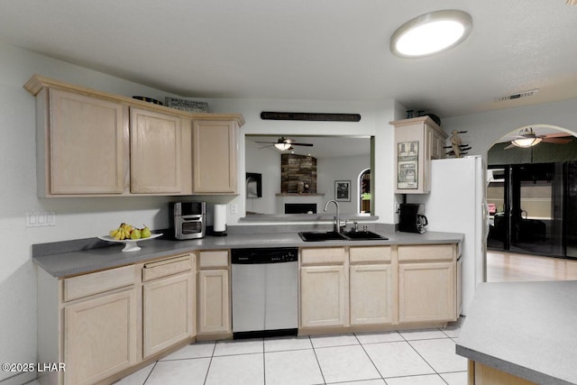 kitchen featuring visible vents, stainless steel dishwasher, light brown cabinetry, a ceiling fan, and a sink