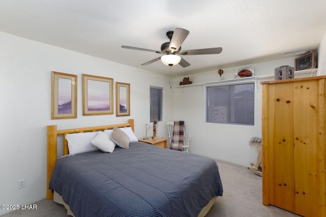 bedroom with ceiling fan, a textured ceiling, and carpet flooring