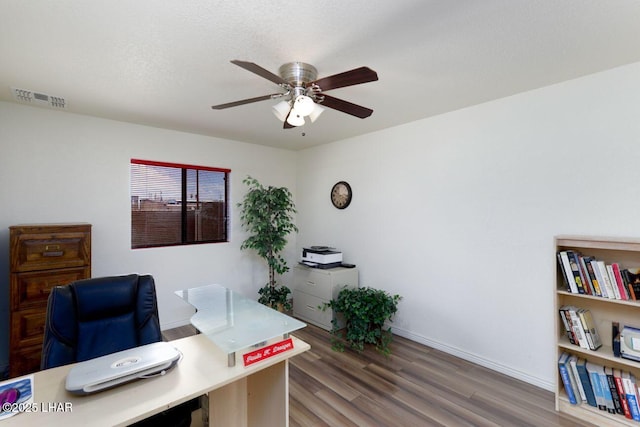 office area featuring visible vents, a ceiling fan, a textured ceiling, wood finished floors, and baseboards