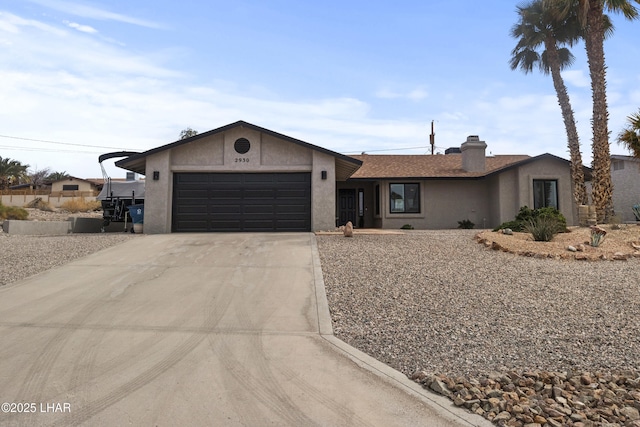 ranch-style house with a garage, driveway, a chimney, and stucco siding