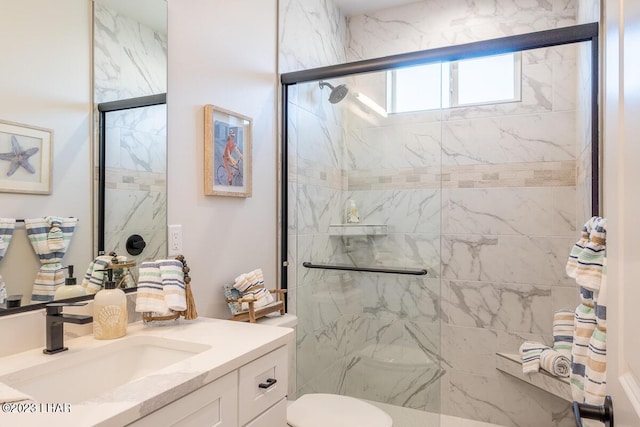 bathroom featuring vanity, toilet, and a shower with shower door