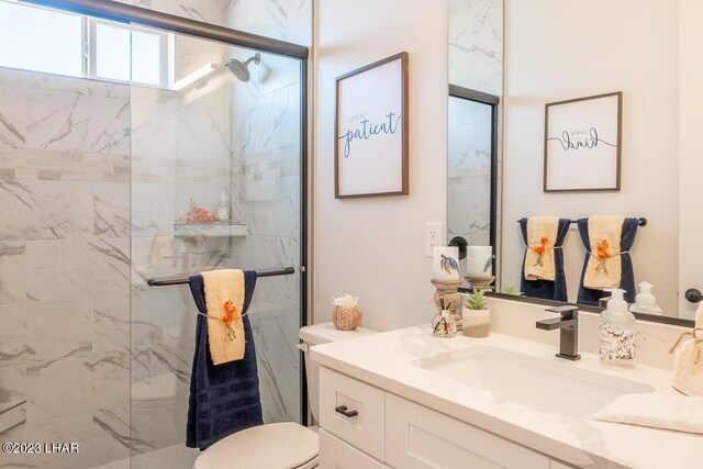 bathroom featuring vanity, toilet, and a shower with shower door