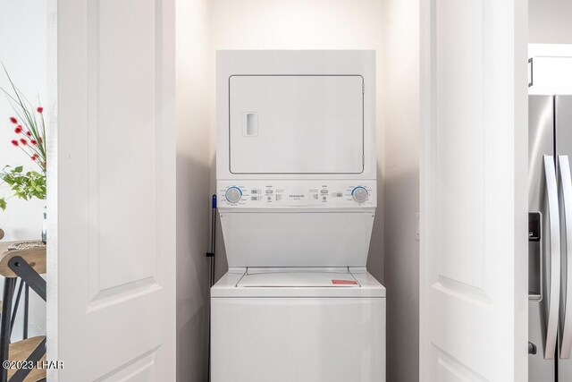 washroom featuring stacked washer and clothes dryer