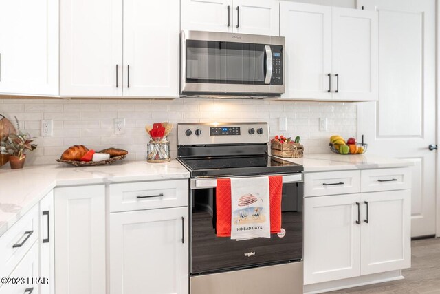 kitchen featuring white cabinetry, appliances with stainless steel finishes, and tasteful backsplash