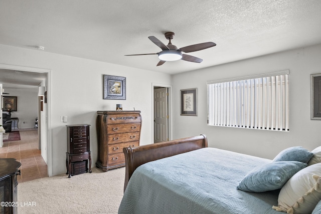 carpeted bedroom featuring a textured ceiling and ceiling fan