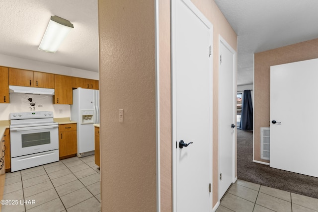 2094 Mesquite Ave Unit 113, Lake Havasu City, AZ 86403 - kitchen featuring white appliances, under cabinet range hood, light tile patterned floors, light countertops, and a textured ceiling