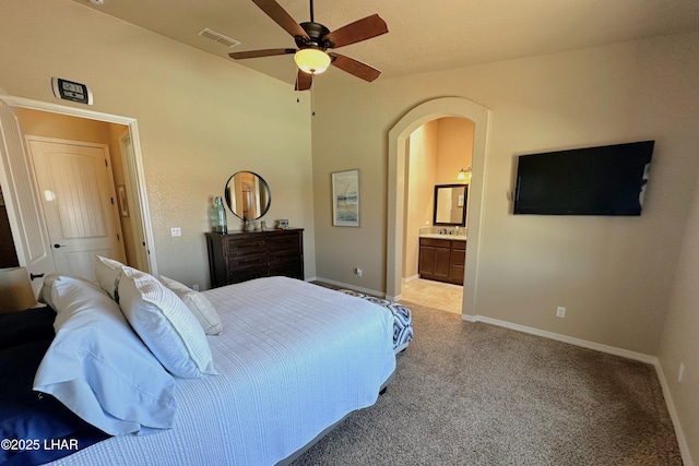 2969 Pony Cir, Lake Havasu City, AZ 86406 - bedroom featuring light carpet, arched walkways, and ensuite bathroom