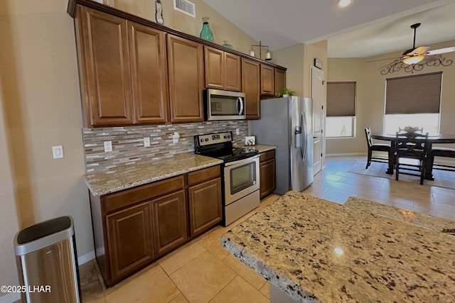 2969 Pony Cir, Lake Havasu City, AZ 86406 - kitchen featuring stainless steel appliances, a ceiling fan, tasteful backsplash, light stone counters, and decorative light fixtures