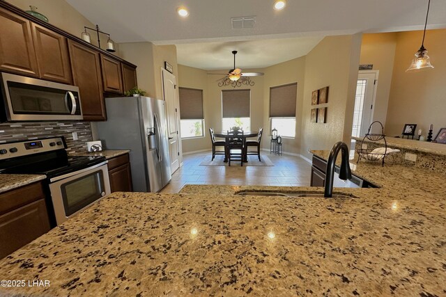 2969 Pony Cir, Lake Havasu City, AZ 86406 - kitchen with appliances with stainless steel finishes, ceiling fan, decorative backsplash, light stone counters, and decorative light fixtures